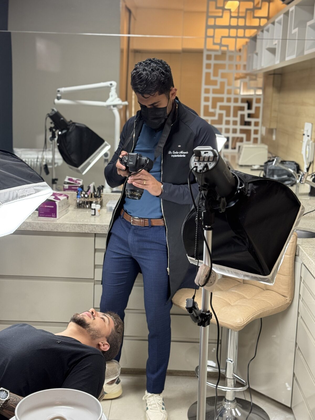 Dr. Carlos Miranda documentando o caso de um paciente com câmera profissional — registro e acompanhamento, clínica no Castelo, Belo Horizonte